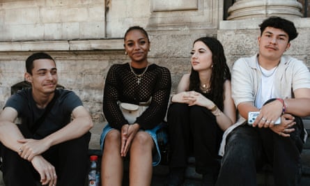 A group of teenagers sitting in front of Lyon’s city hall.