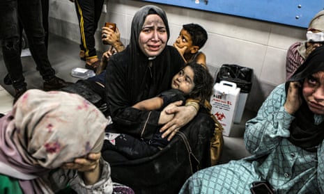 Crying women in hijabs sitting on a hospital floor