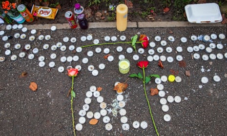 Small candles spell out the name 'Alf' with other candles, three roses, and soft drinks and sweet wrappers around