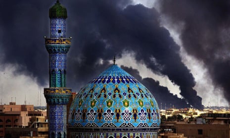 The Shahid mosque in Baghdad stands tall against a backdrop of oil fires