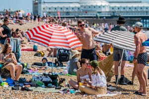 Brighton, England People on the beach relax in swimwear under blue skies