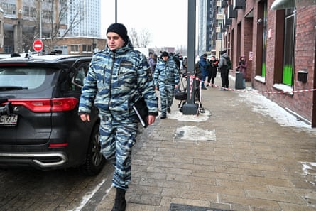 Police officers walk past a the scene of the shooting in Moscow