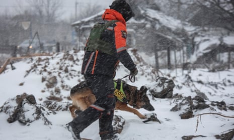 A rescuer with a dog works at the site of a Russian missile strike in the town of Pokrovsk