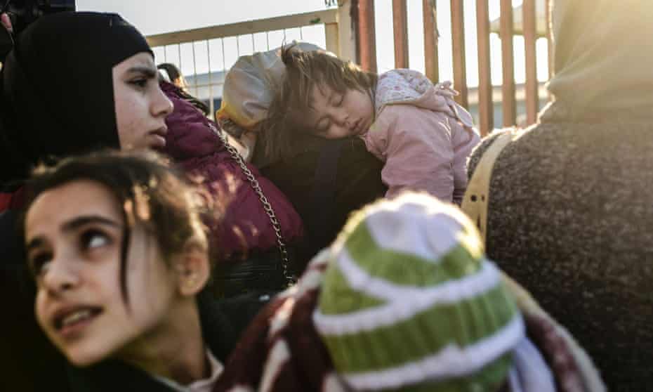 Syrian families at a border gate in Turkey