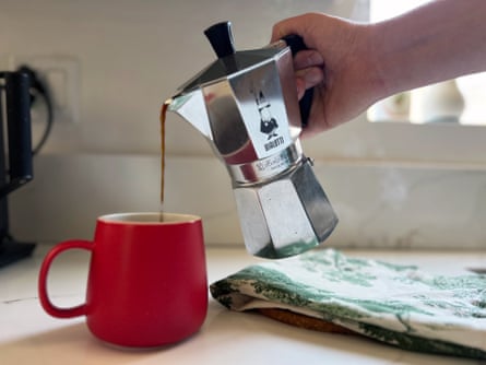 A red Moka Pot having coffee poured in it