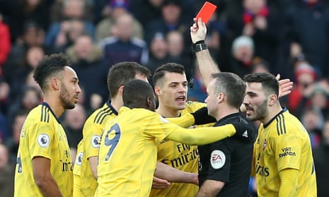 Paul Tierney shows Pierre-Emerick Aubameyang a red card after VAR upgraded a yellow card he received for a foul on Max Meyer. 