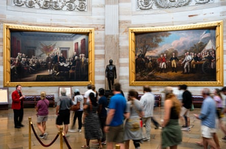 People congregate in a rotunda to look at two paintings