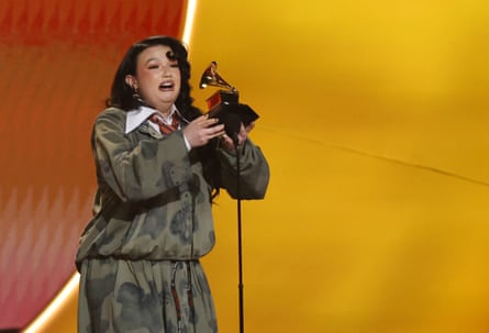 Lola Young on stage looking emotional collecting her award