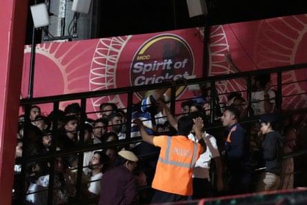 A policeman gestures to spectators leaving the game in Dharamshala