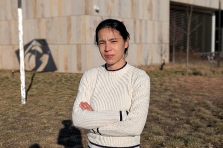 a woman stands with her arms crossed outside