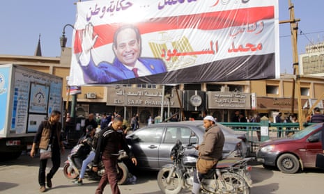 People walk underneath an election campaign banner for Abdel Fatah al-Sisi in Cairo.