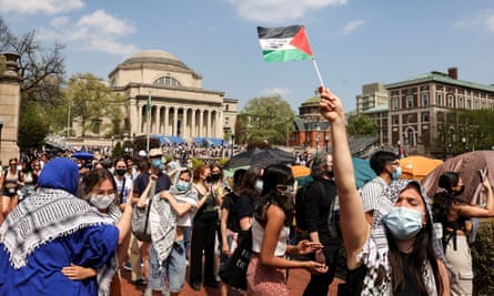 people gather on campus, one waving a palestinian flag