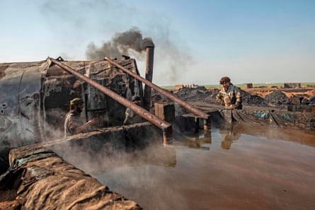 Men work at a primitive oil refinery in countryside outside al-Qahtaniyah, a town in Syria’s north-eastern Hasakeh province