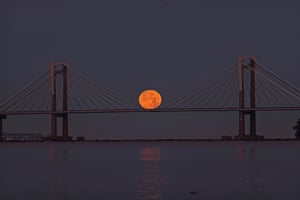 The full moon peeks out over the estuary of Vigo and behind the Rande Bridge during a penumbral lunar eclipse seen overnight. A penumbral lunar eclipse is a natural phenomenon that occurs when the Earth is aligned in a near-straight line with the Sun and the Moon, thus blocking some sunlight from directly reaching the Moon’s surface and casting a penumbra, or shadow, on our planet’s sole natural satellite