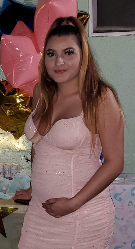 A girl wearing a pink dress clutching her belly
