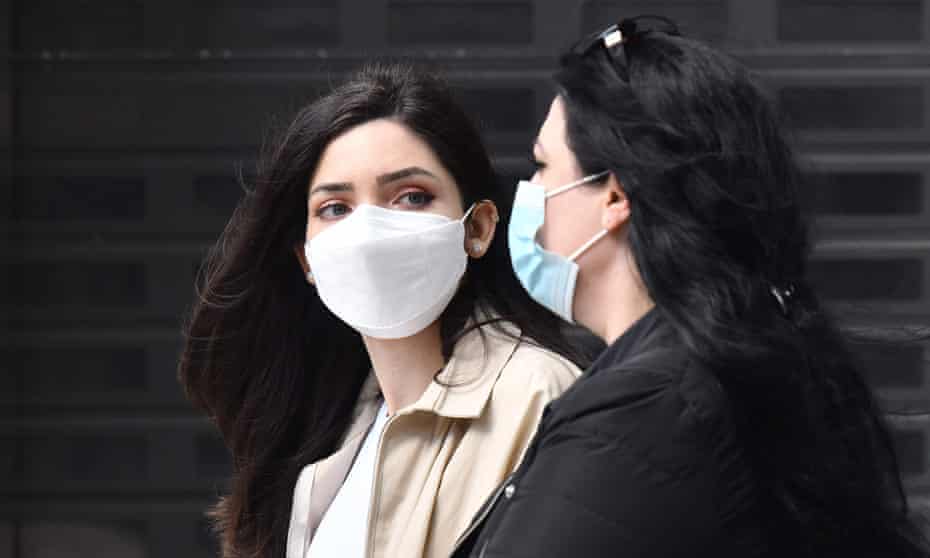 Pedestrians wear face masks