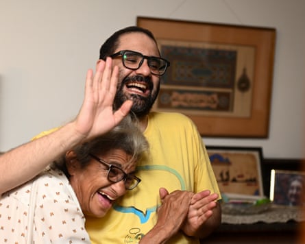 Laila Soueif buries her head in Alaa Abd-el-Fattah’s chest as he waves to a well-wisher and both smile