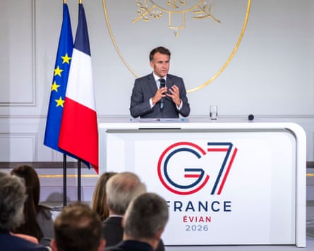 Emmanuel Macron speaks in Paris before the summit from behind a desk with the G7 logo. EU and French flags stand to his side.