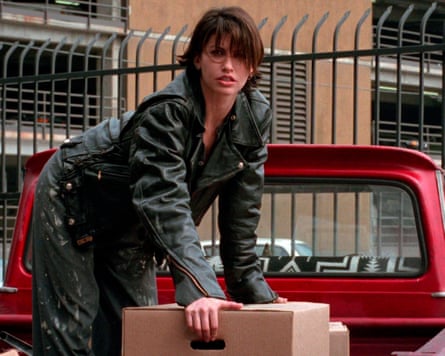 Gina Gershon in the back of a red pickup truck.