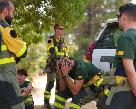 Aesir Diaz, 31, a technician with Spain's Forest Fire Reinforcement Brigades (BRIF), center, sits next to teammates during a break from battling a wildfire in Sotillo de Adrada, Ávila province, Spain.