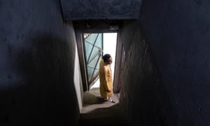 Nisar Ahmed a Muslim man in Delhi who has come forward to be a key witness in a number of trials connected to the 2020 anti-Muslim riots. Pictured from a distance in a doorway down a dark corridor