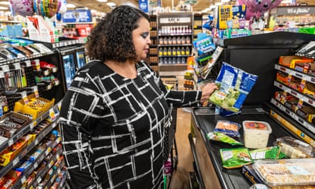 Tania Whitfield places her items on a conveyor checkout line at a Kroger grocery store in Lexington, Kentucky, on 14 October 2022.