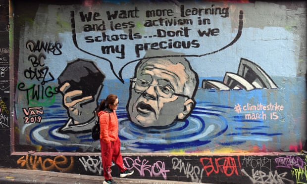 A person walks past a mural showing prime minister Scott Morrison holding a lump of coal