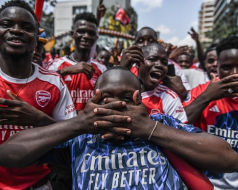 Arsenal supporters wearing shirts and waving flags