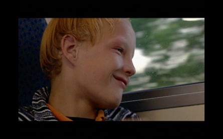 A boy smiling looking out of the window