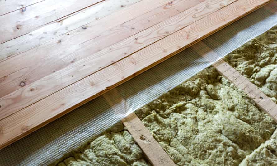 Installation of a floor of wooden natural planks and mineral wool insulation.