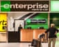 Enterprise green car hire sign over a desk at an airport.