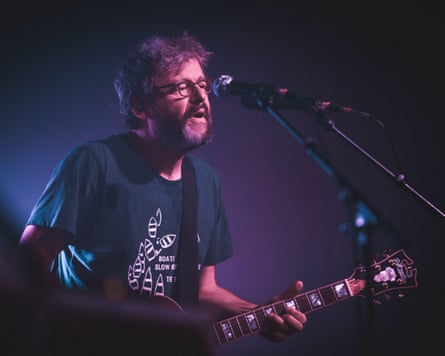 The Notwist’s Markus Acher on stage playing guitar.