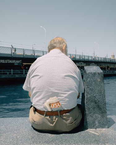 An old man sitting on a waterside