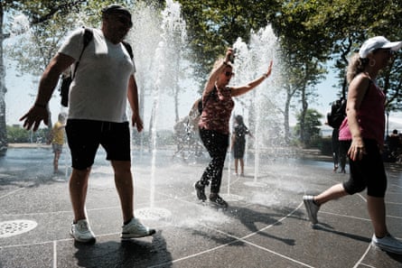 Children and adults cool off in a fountain in a lower Manhattan park in New York City.