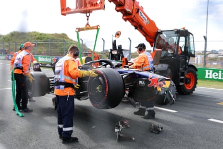 Max Verstappen’s damaged Red Bull car is lifted off the track