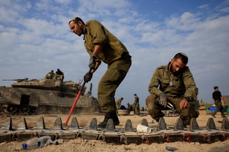 Israeli soldiers repair tanks near the Israel-Gaza border