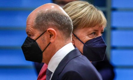 German minister of finance Olaf Scholz crosses paths with Merkel.