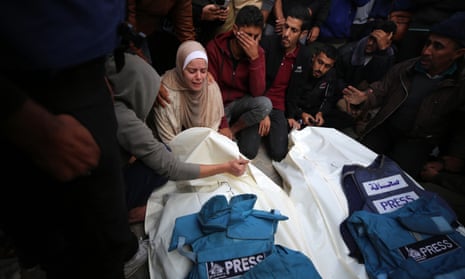 Journalists, relatives and friends pray over the bodies of journalists Sary Mansour and Hassouna Sleem.