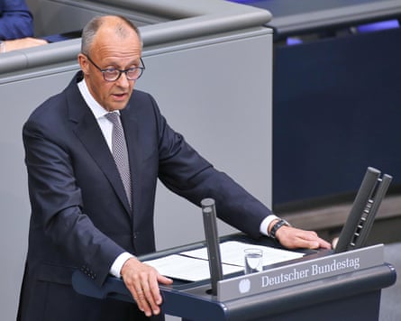 Friedrich Merz standing at a podium in the German parliament