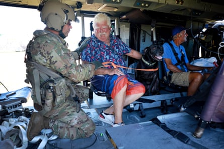 Tom O’Sullivan his dog Jack and Harry Marquard prepare to be evacuated in a Florida army national guard helicopter from Pine Island.