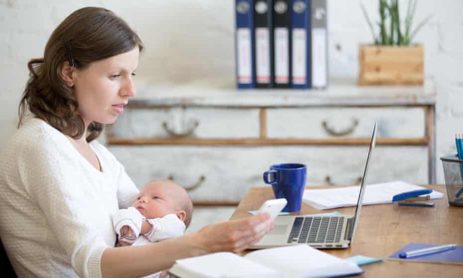 women with baby works from home with laptop and mobile phone
