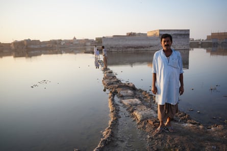 Mohammed Siddique, followed by some of his seven children, makes the perilous journey to his home