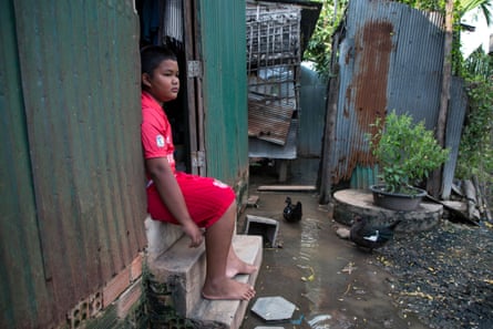 Chan Pheakdey, 10, sits in the doorway of his house.