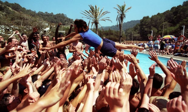 A holiday rep dives into a crowd of people at a pool party for Club 18-30 holidaymakers in Ibiza in 2001.