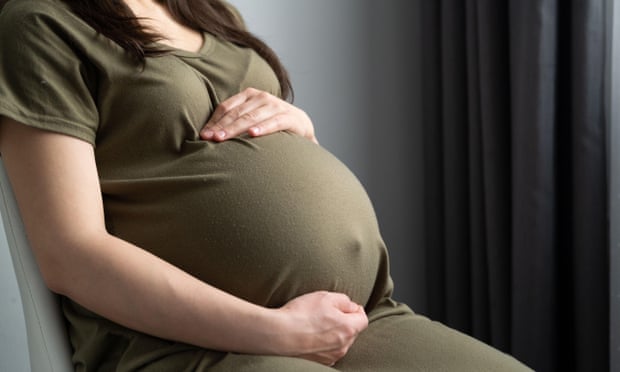 Pregnant woman with hands around belly