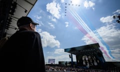 A D-Day veteran stands to watch a fly-past by the Royal Air Force aerobatics team, "The Red Arrows" as they pass over a D-Day 80th anniversary concert in Portsmouth.