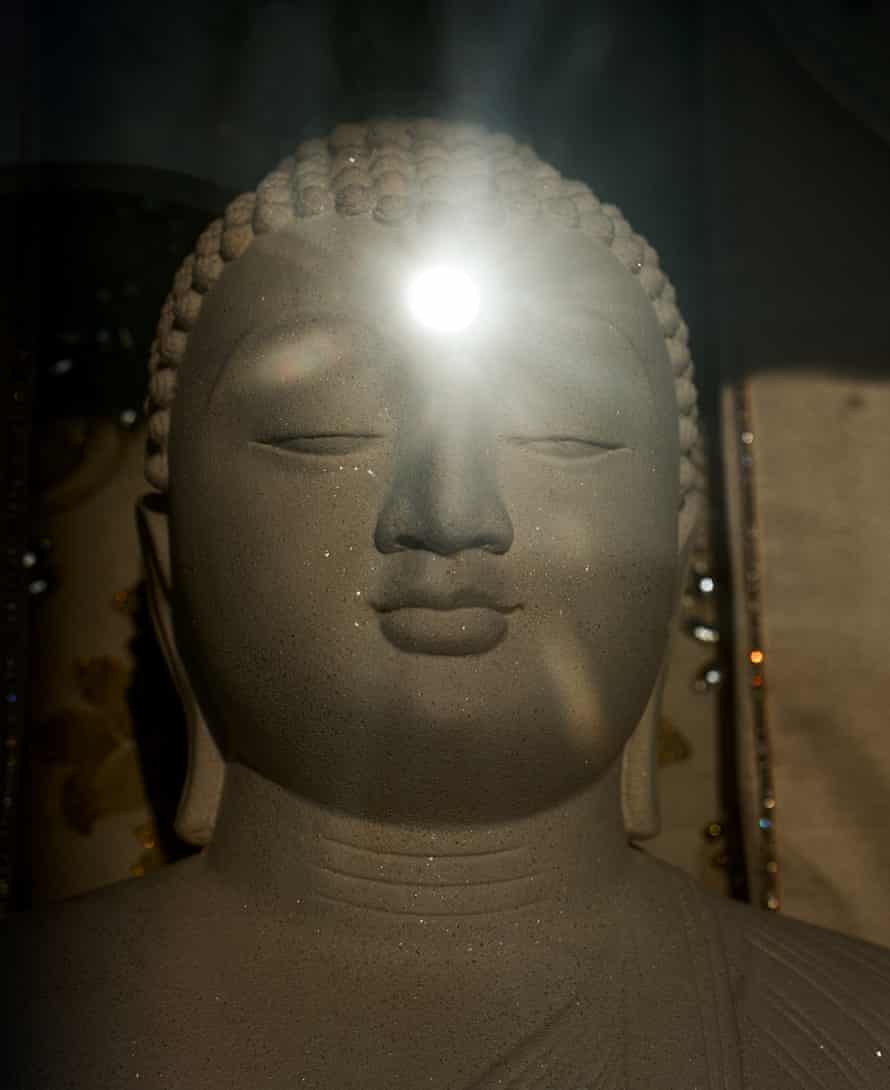 Light reflecting off a stone Buddha statue