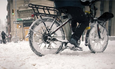 A bicycle food delivery worker rides his bike through heavy snow in New York, February 2021.