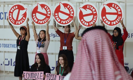 A man wearing a red keffiyeh typical in Saudi Arabia looks on as activists protest against fossil fuels on day ten of the UNFCCC COP28 Climate Conference at Expo City Dubai on December 10, 2023 in Dubai, United Arab Emirates.