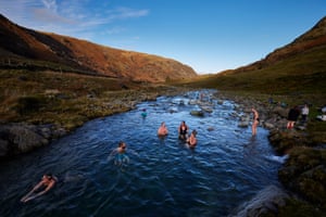 Borrowdale, UK. The author Sara Barnes (red swimsuit) takes a dip with fellow cold water enthusiasts in Spirit Pool – her self-named mountain beck pool.